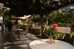 a table with a flower in a vase on a patio at G&P Rooms Matala in Matala