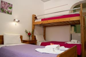 two beds in a room with two bunk beds at G&P Rooms Matala in Matala
