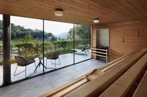 a room with a large glass wall with chairs and a table at ElzLand Hotel Pfauen WELLNESS & SPA in Elzach