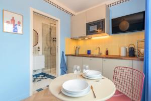 a kitchen and dining room with a table and chairs at Le Cottage du Louvre in Lens +183 photos