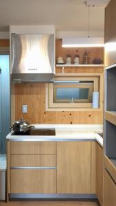 a kitchen with wooden cabinets and a microwave at Summer's House in Jeju