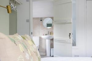 a white bathroom with a sink and a mirror at The Ash Tree in Ashendon +36 photos