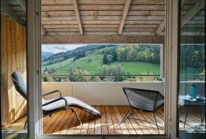 a room with a large window with chairs on a balcony at ElzLand Hotel Pfauen WELLNESS & SPA in Elzach +37 photos