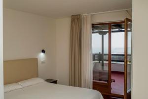 a hotel room with a bed and a balcony at Hotel Montañés in Suances