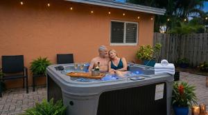 a man and woman sitting in a hot tub at Hidden Gem Vacation Villa w Private Pool & TikiHut in Fort Lauderdale