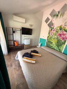a bedroom with a large bed with two towels on it at Villa Mbita Sardegna in Brunella