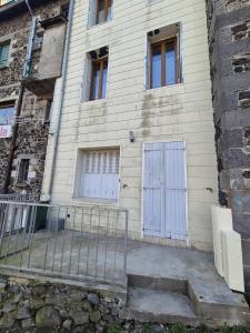 a building with two white doors and a gate at Studio Spa Murol Centre Relaxation in Murol +4 photos