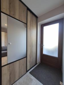 a room with a door with a window and a mirror at Studio Spa Murol Centre Relaxation in Murol