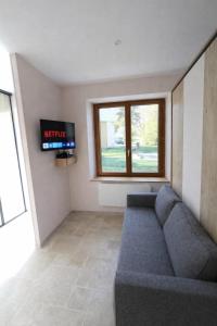 a living room with a couch and a tv at Studio Spa Murol Centre Relaxation in Murol