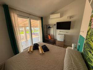 a bedroom with a bed and a large window at Villa Mbita Sardegna in Brunella