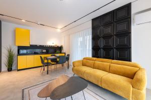 a living room with a yellow couch and a table at Nova Apartments in Prizren