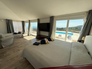 a bedroom with two beds and a view of a pool at Villa Mbita Sardegna in Brunella