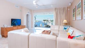 a living room with a white couch and a television at 115 Mariners Club in Key Largo