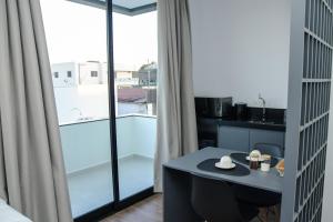 ein Zimmer mit einem Tisch und einem großen Fenster in der Unterkunft Caza Flat Hotel in Constantina