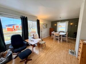 a living room with a table and a dining room at Cozy House by the Lake in Vestvågøya