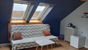 a living room with a couch and two windows at Mrągowo Pokoje nad jeziorem i Apartament rodzinny in Mrągowo