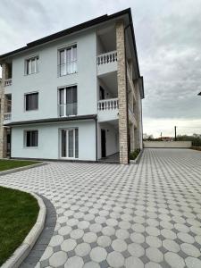 a large white building with a stone driveway at Villa Billa in Tirana