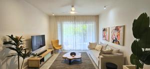 a living room with a couch and a tv at Tropical - Resort - Spa - Pool & Garden in Grand-Baie