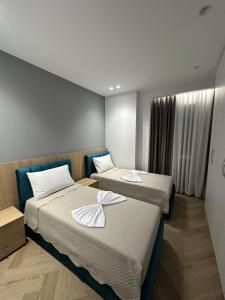 a hotel room with two beds with towels on them at Villa Billa in Tirana