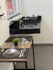 a table with plates and utensils on it in a kitchen at Voer Jequitibá Hospedaria in Jequitibá +35 photos