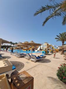 a resort with a pool with chairs and umbrellas at Studio at El Karma Beach & Aqua Park in Hurghada