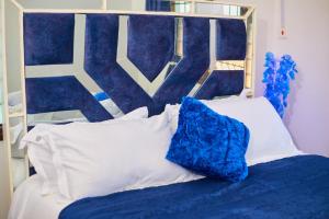 a bed with a blue headboard and white pillows at Cutie 3 br Villa Nyali in Mombasa