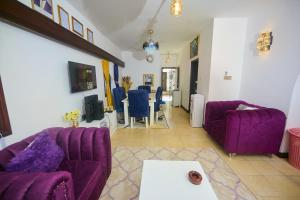 a living room with purple couches and a table at Cutie 3 br Villa Nyali in Mombasa
