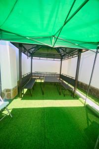a large green tent with benches in a room at Cutie 3 br Villa Nyali in Mombasa
