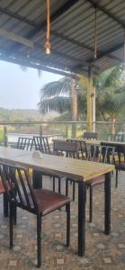 a large wooden table and chairs under a roof at Hotel bright house in Calangute