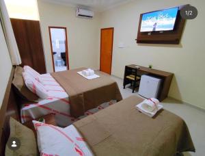 a room with two beds and a flat screen tv at Monte Santo palace hotel in Monte Santo +5 photos