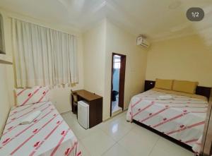 a hotel room with two beds and a mirror at Monte Santo palace hotel in Monte Santo