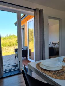 a dining room with a table and a view of a bedroom at VIEW of SMEREK- domki z klimatyzacją in Smerek +47 photos