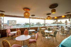 a restaurant with tables and chairs and a large window at Hacienda in Saly Portudal