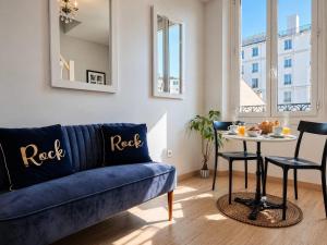 a living room with a blue couch and a table at Suite Notre Dame - Appartements in Cannes