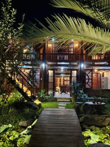 a wooden walkway leading to a house at night at Núi Dinh Stilt House - Phú Mỹ in Ấp Long Cát