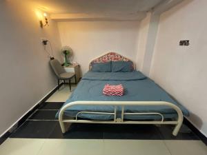a bedroom with a bed with a blue comforter and a chair at Arecrata in Phnom Penh