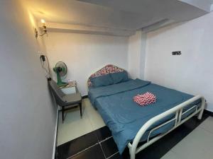 a small room with a bed and a chair at Arecrata in Phnom Penh