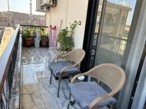 a patio with two chairs and a balcony with a view at Fatah apartment 12 in Luxor