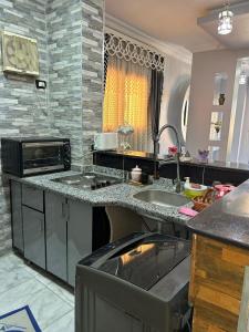 a kitchen with a sink and a microwave at Fatah apartment 12 in Luxor