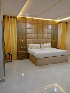a bedroom with a large bed and yellow curtains at Motion Hotel and Suites, Uyo in Uyo