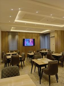 a restaurant with tables and chairs and a flat screen tv at Motion Hotel and Suites, Uyo in Uyo +36 photos