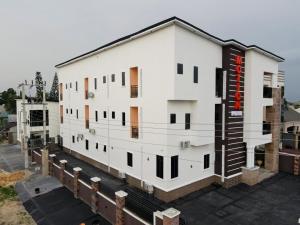 a large white building with a red sign on it at Motion Hotel and Suites, Uyo in Uyo