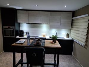a kitchen with a table with chairs and a sink at Suites et Wellness des Champs-Elysées in Ciney