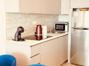 a small kitchen with a sink and a refrigerator at Hillside Apartment with Sea View in Budva +20 photos