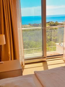 a bedroom with a large window with a view of the ocean at Hillside Apartment with Sea View in Budva
