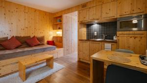 a kitchen and living room with a couch and a table at La ferme des Colieuvres in Lièpvre