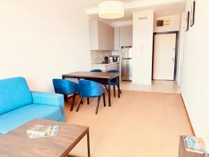 a living room with a blue couch and a table at Hillside Apartment with Sea View in Budva