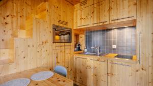 a kitchen with wooden cabinets and a table and a sink at La ferme des Colieuvres in Lièpvre +41 photos