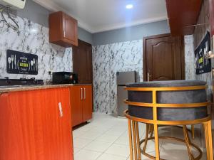 a kitchen with a counter and a bar stool at Max Heron in Ikeja +37 photos