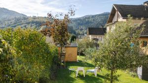 a garden with two chairs and an apple tree at La ferme des Colieuvres in Lièpvre